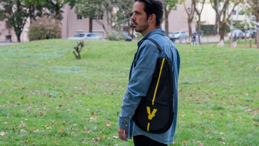 A man standing in a field with a backpack on his back